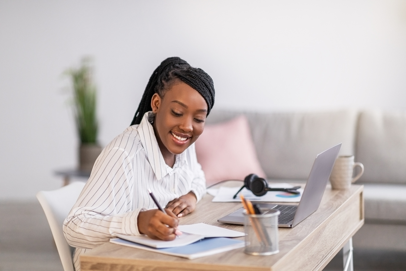 Pretty black woman student studying in front of laptop